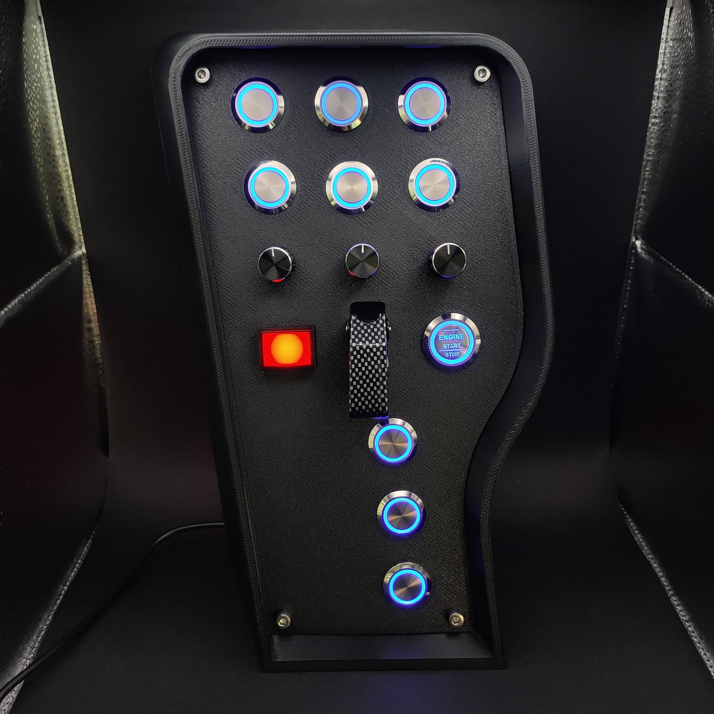 Front view with carbon fibre toggle cover, highlighting the professional matte faceplate and the chrome accents on the buttons.