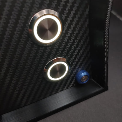 Detail shot of blue anodised aluminium bolt trim and white LED illuminated chrome buttons on carbon.