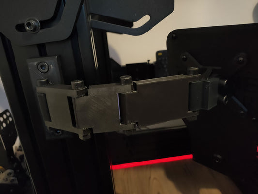 The OSG Mounting Arm attached to a sim rig, securely holding an OSG button box at the perfect racing angle.