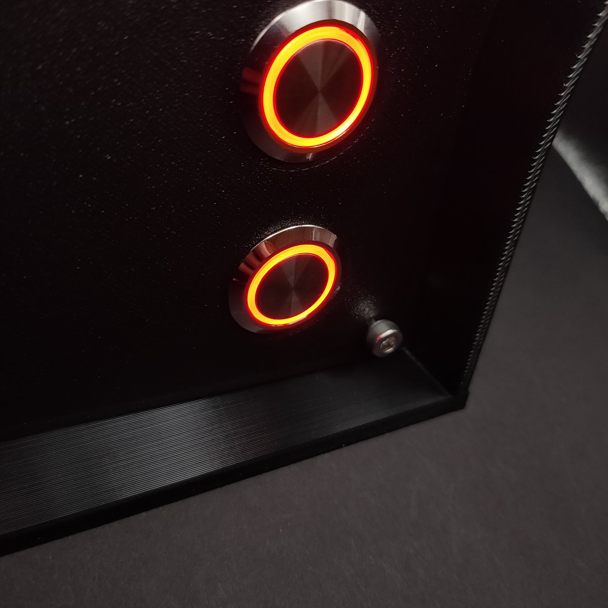 Detail shot showing the contrast between the premium chrome button housings with red LEDs and the rugged, non-reflective matte front panel.