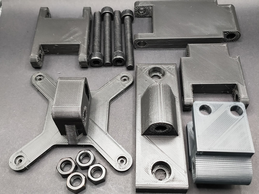 Complete kit contents: modular arm segments, button box mounting plate, M8 bolts, and T-nuts for full customisation of your sim rig setup.