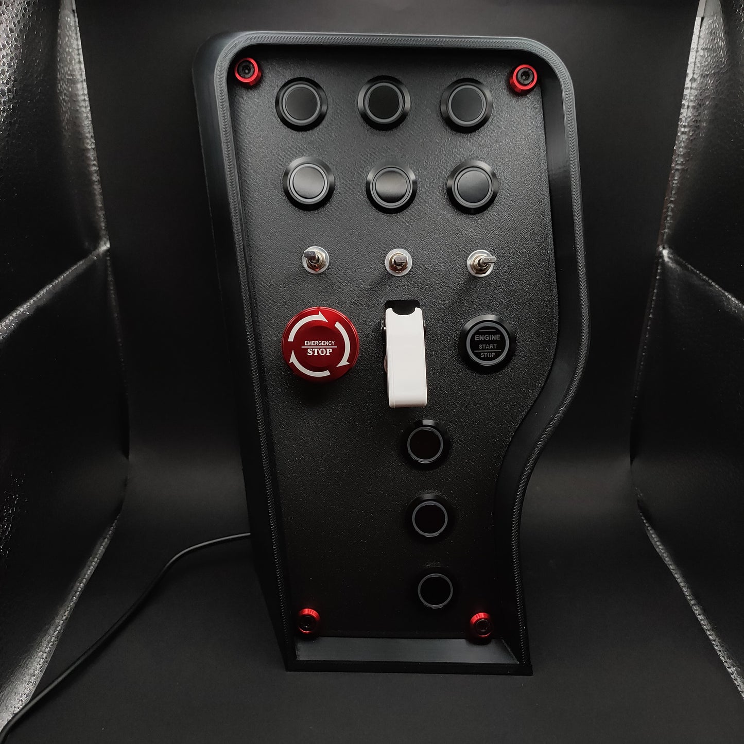 Nürburgring Edition sim box showing the red anodised E-Stop with matching hardware trim and matte black finish (LEDs off).