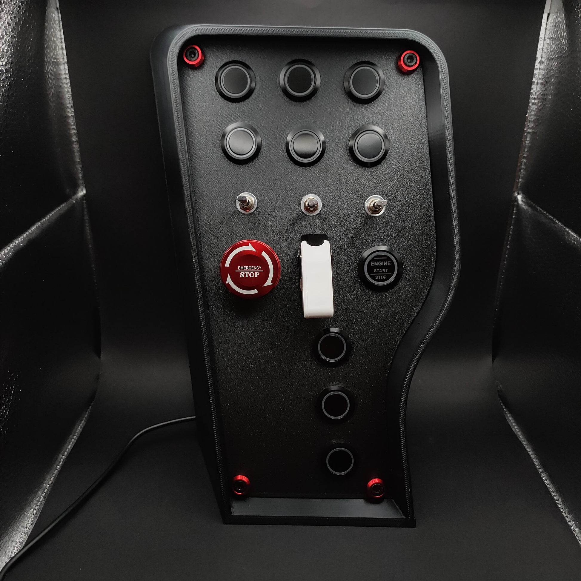 Nürburgring Edition sim box showing the red anodised E-Stop with matching hardware trim and matte black finish (LEDs off).