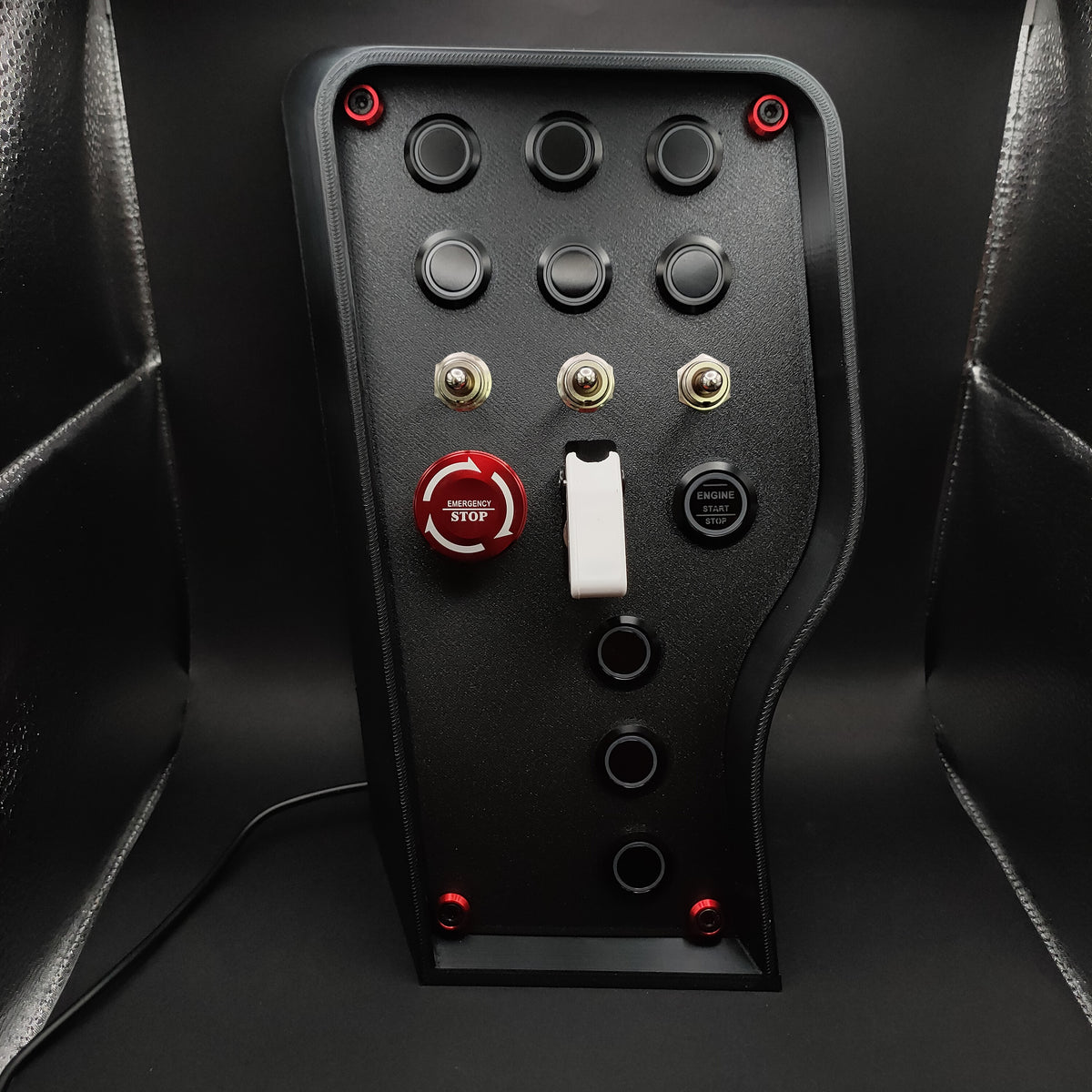 Nürburgring Edition sim box showing the red anodised E-Stop with matching hardware trim and matte black finish (LEDs off).