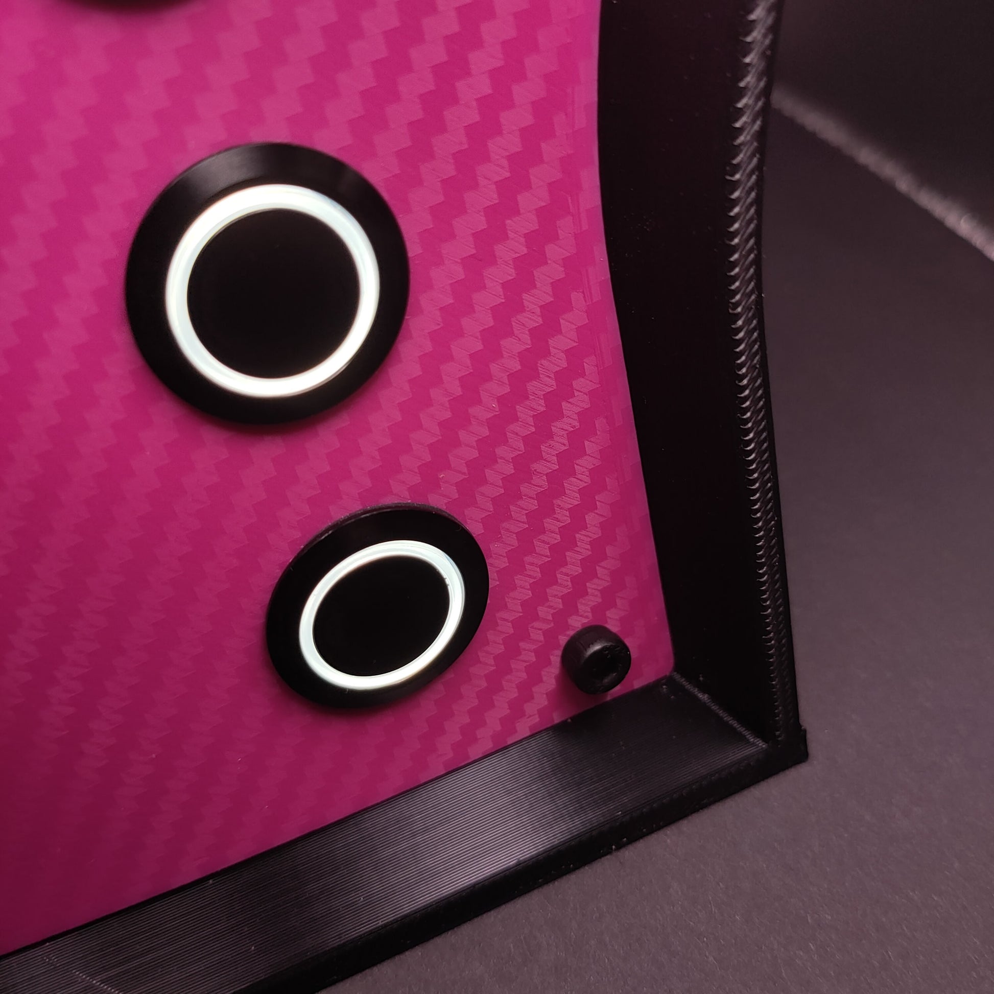 Detail shot of the unique pink carbon fibre faceplate and contrasting black hardware.