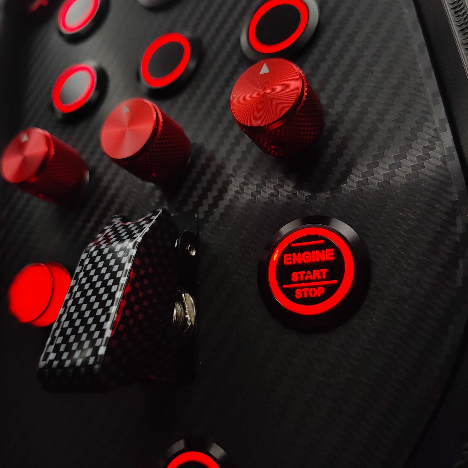Detail shot of red machined aluminium encoders and red LED Engine Start button on Sport+ Red.