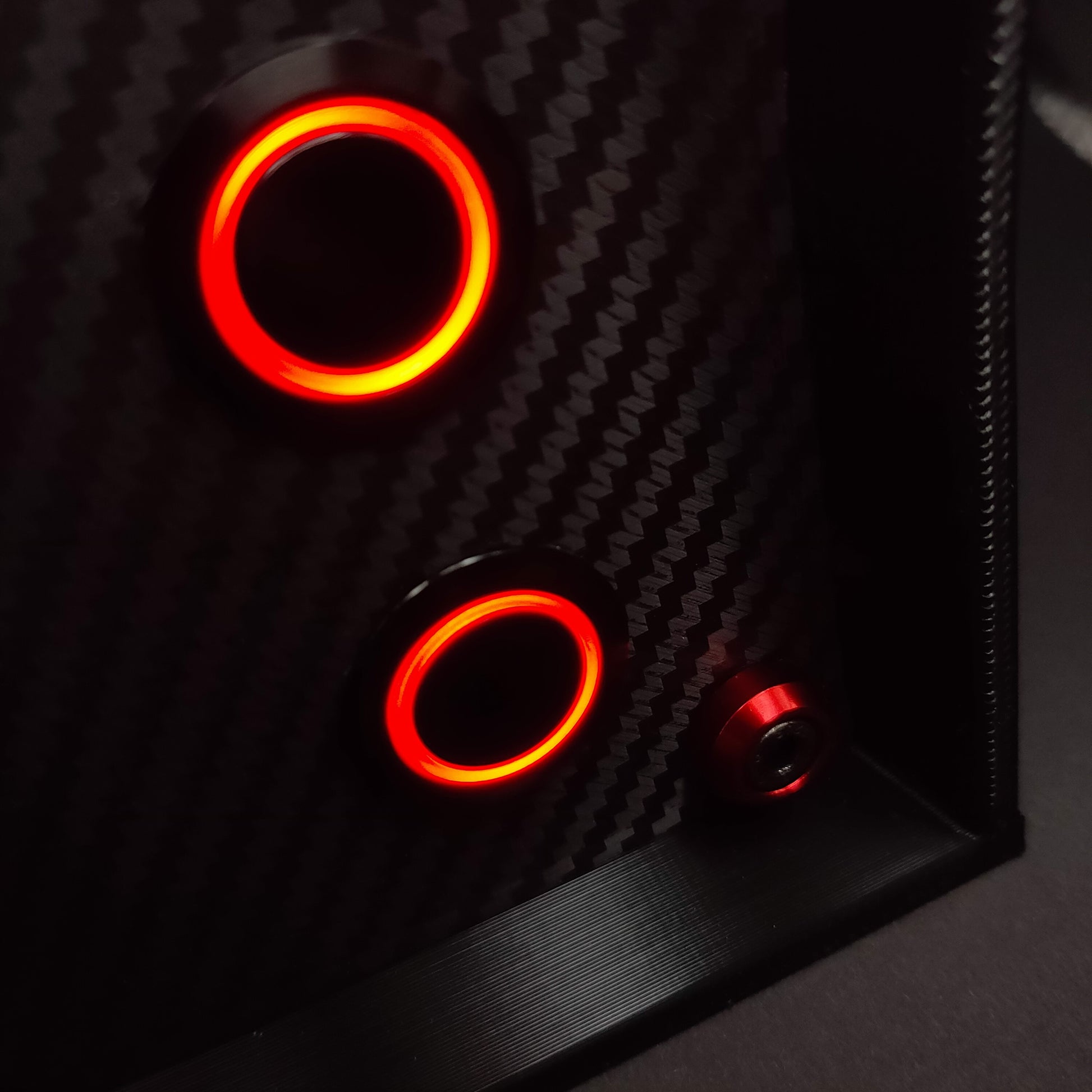 Close-up of red anodised aluminium bolt trim and red LED momentary push buttons on carbon fibre.