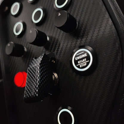 Close-up of black machined aluminium rotary encoders on a carbon fibre faceplate.