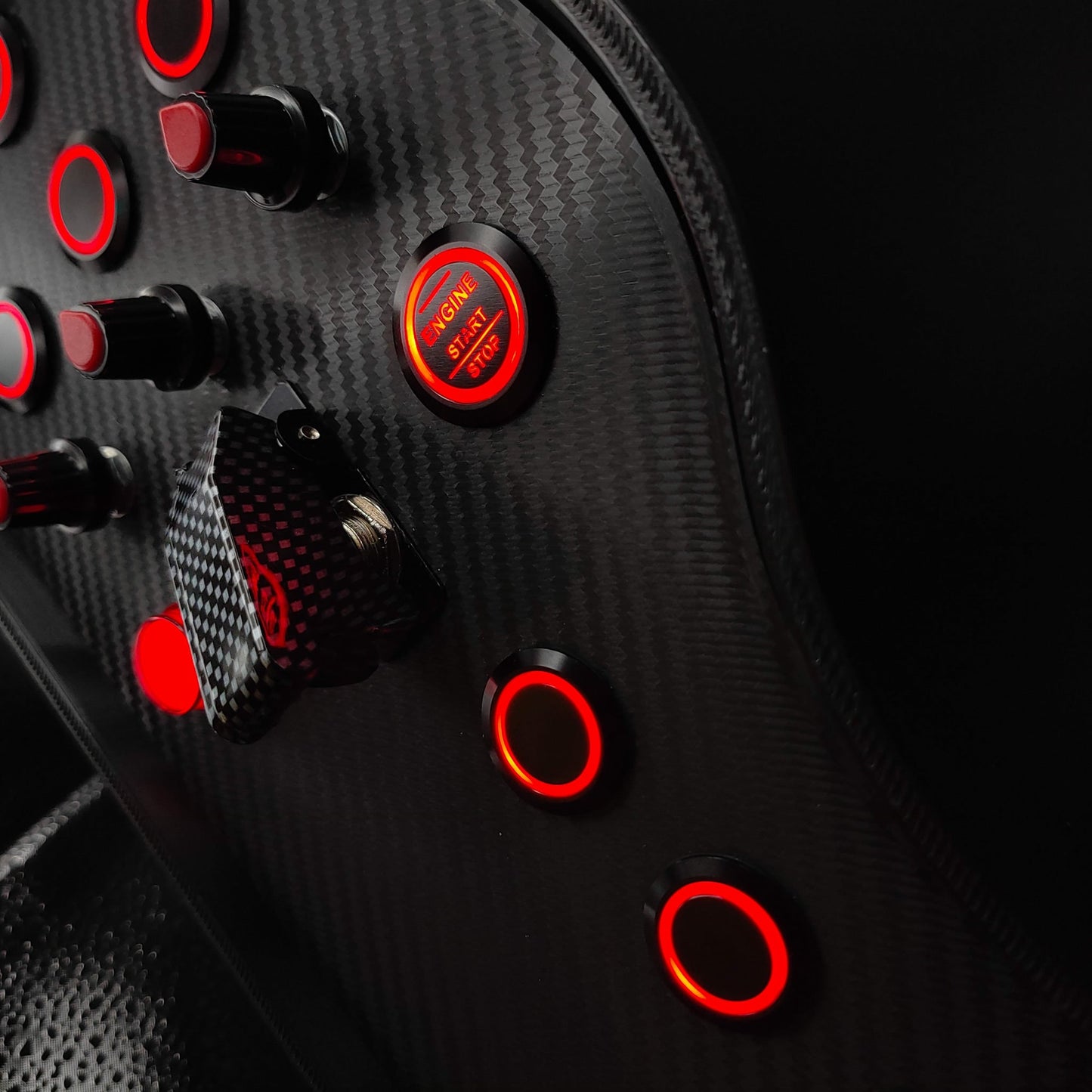 Detail shot of black textured rotary encoders and red LED Engine Start button on Sport Red edition.