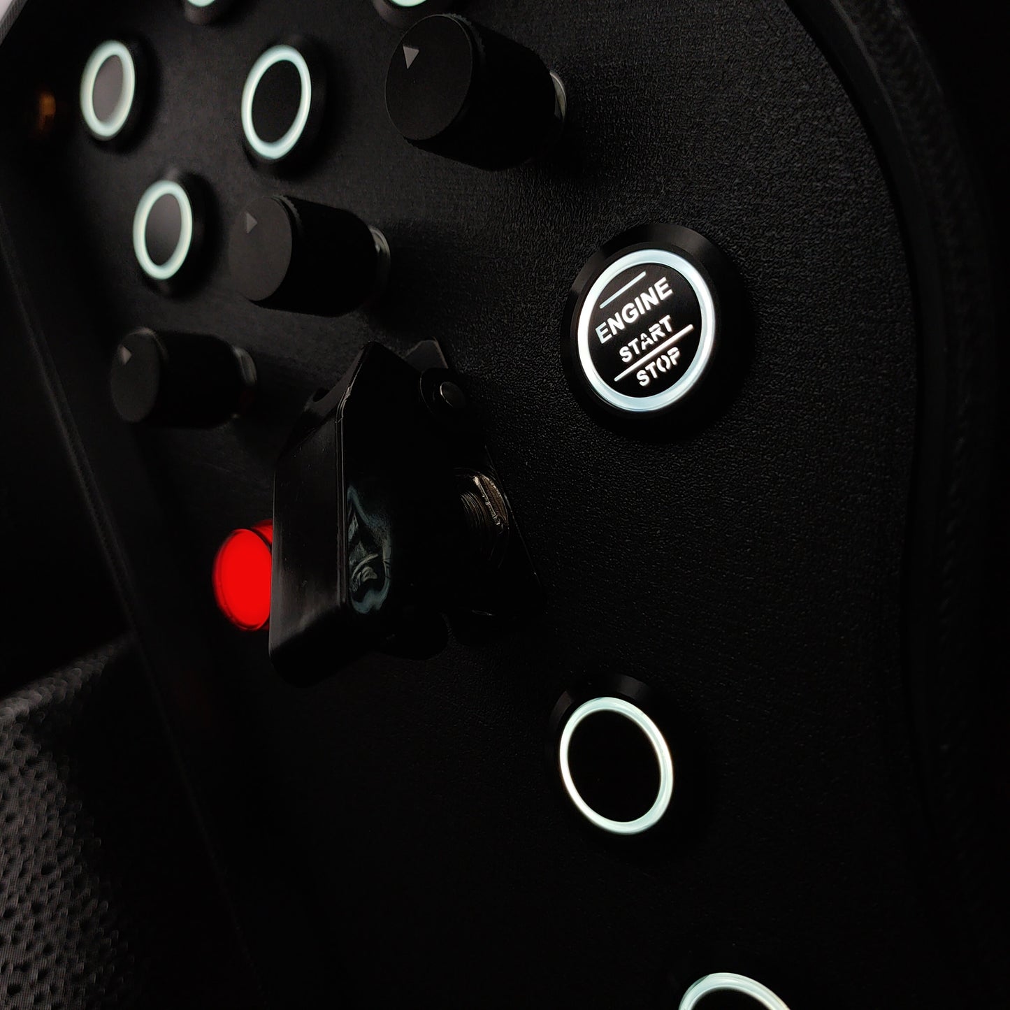 Close-up of black machined aluminium rotary encoders and white LED start button on Gold Edition.