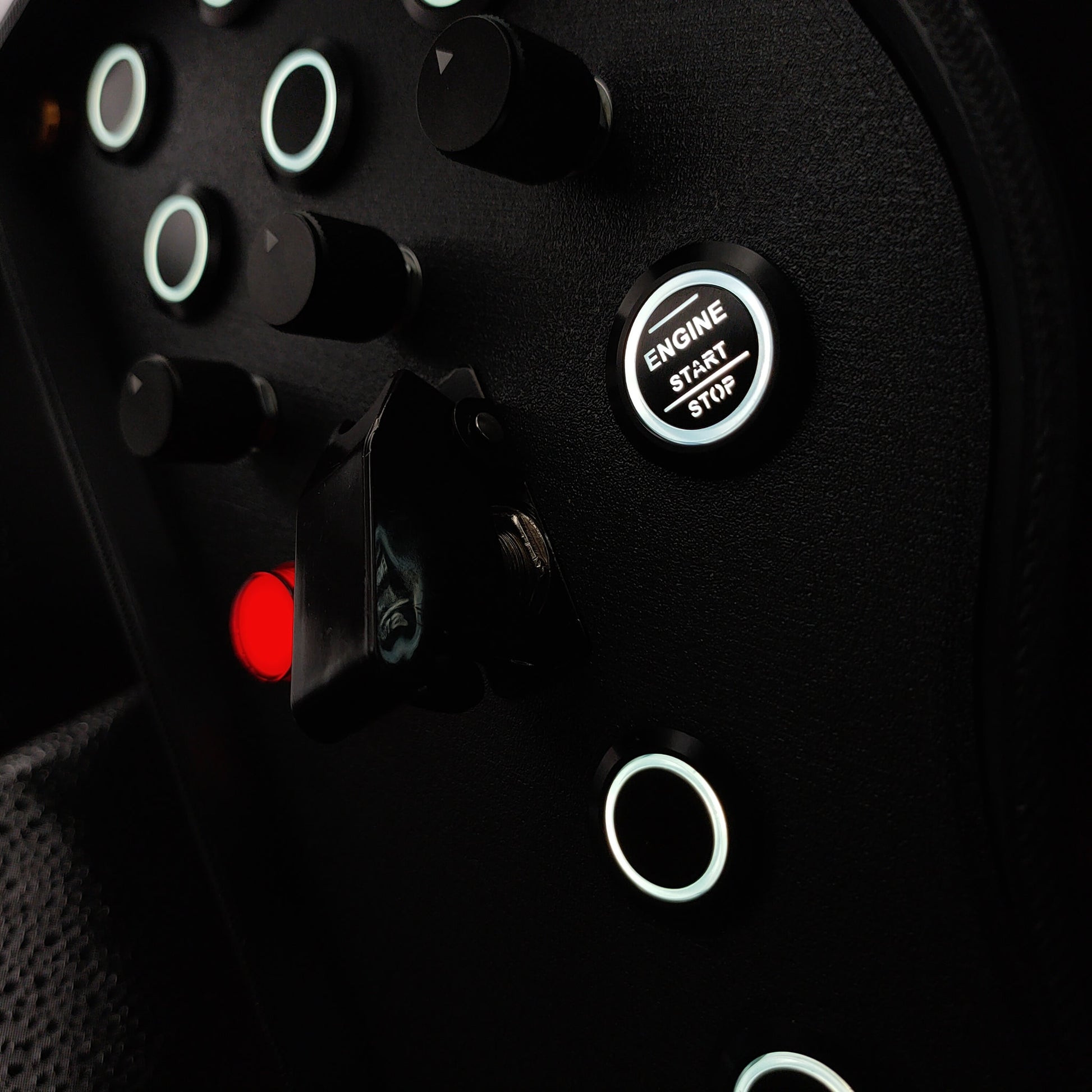 Close-up of black machined aluminium rotary encoders and white LED start button on Gold Edition.